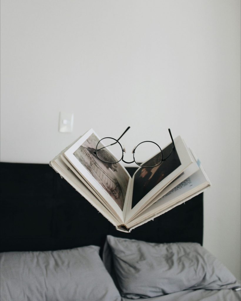 Open book floating with glasses on top