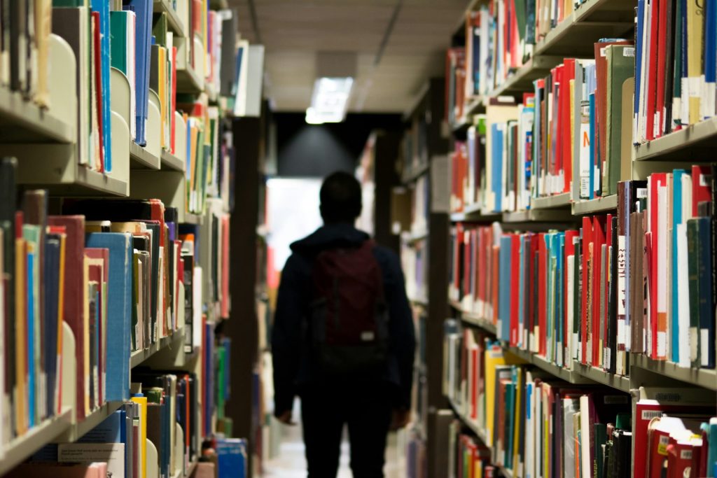 Individual walking through a library aisle