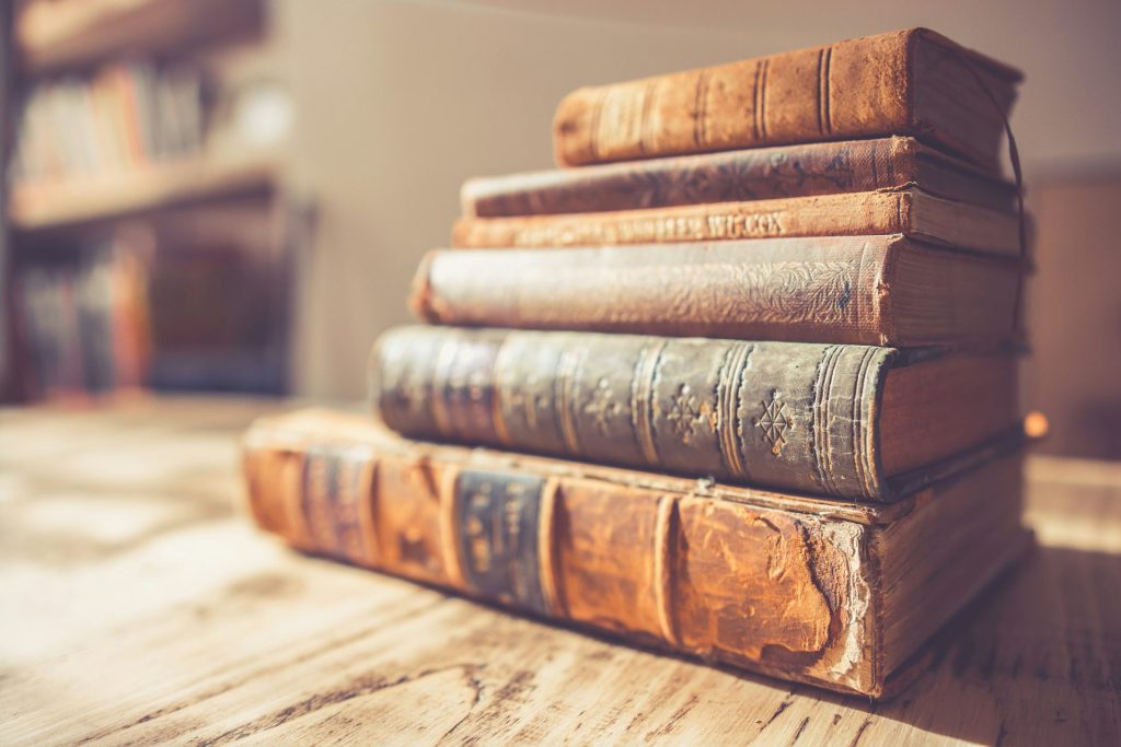 Vintage books piled together with worn covers.