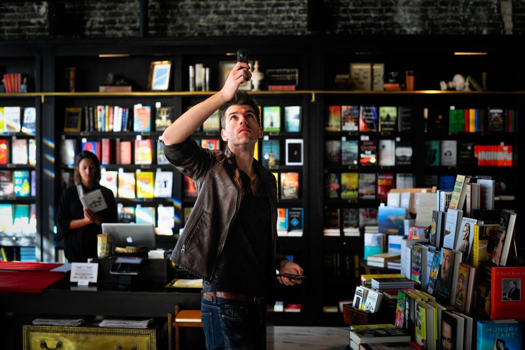 Man looking up in a bookstore.